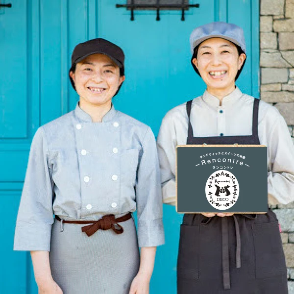 ランコントレの看板を持つ富沢誌織さんと長井可奈子さん